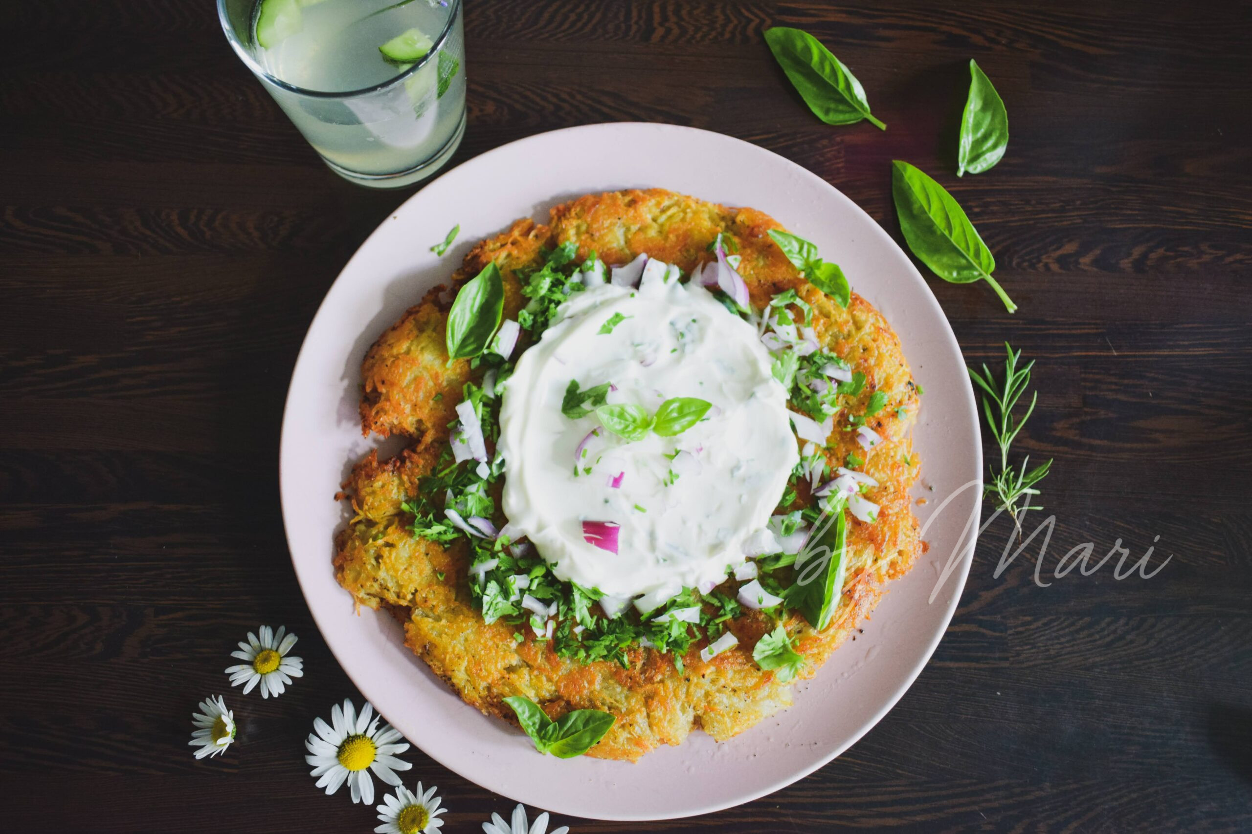 Картофельный рёшти с йогуртовым соусом на тарелке