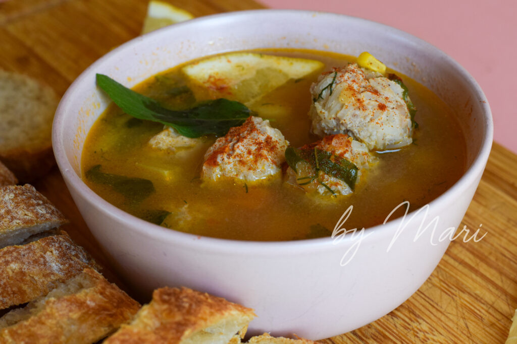 суп с фрикадельками, картофелем и томатами на фоне лайма и зелени