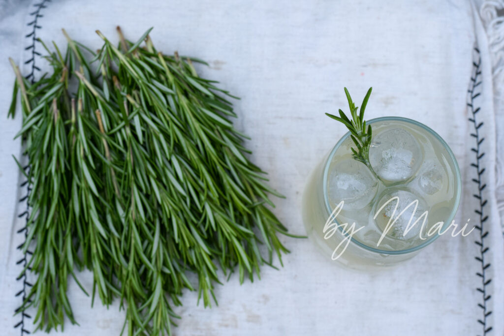 Свежая веточка розмарина рядом с лимонадом