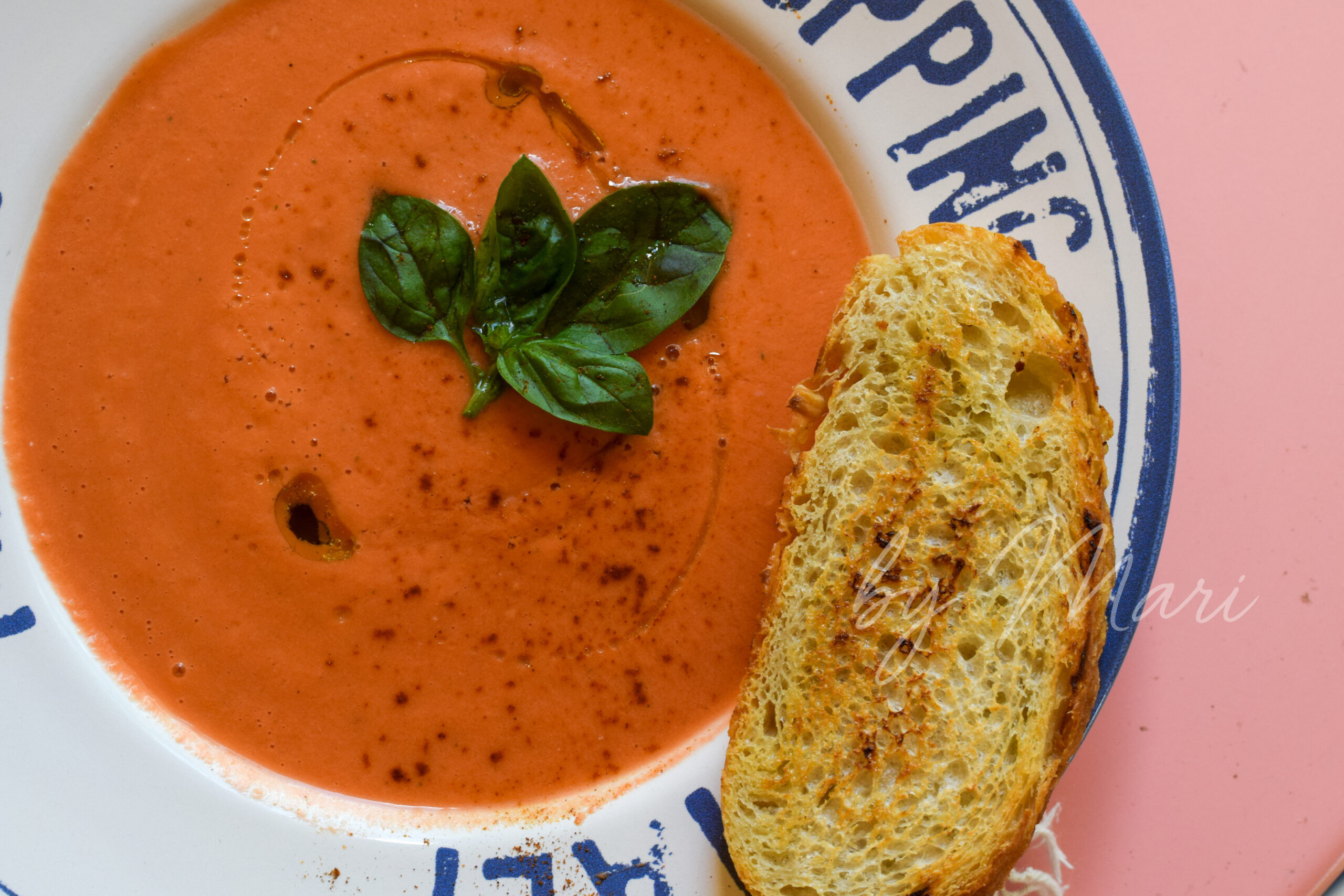 Классический гаспачо в тарелке с овощами и базиликом