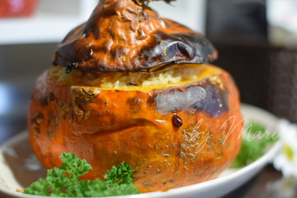 разрезанная запечённая тыква с рисовой начинкой и курицей